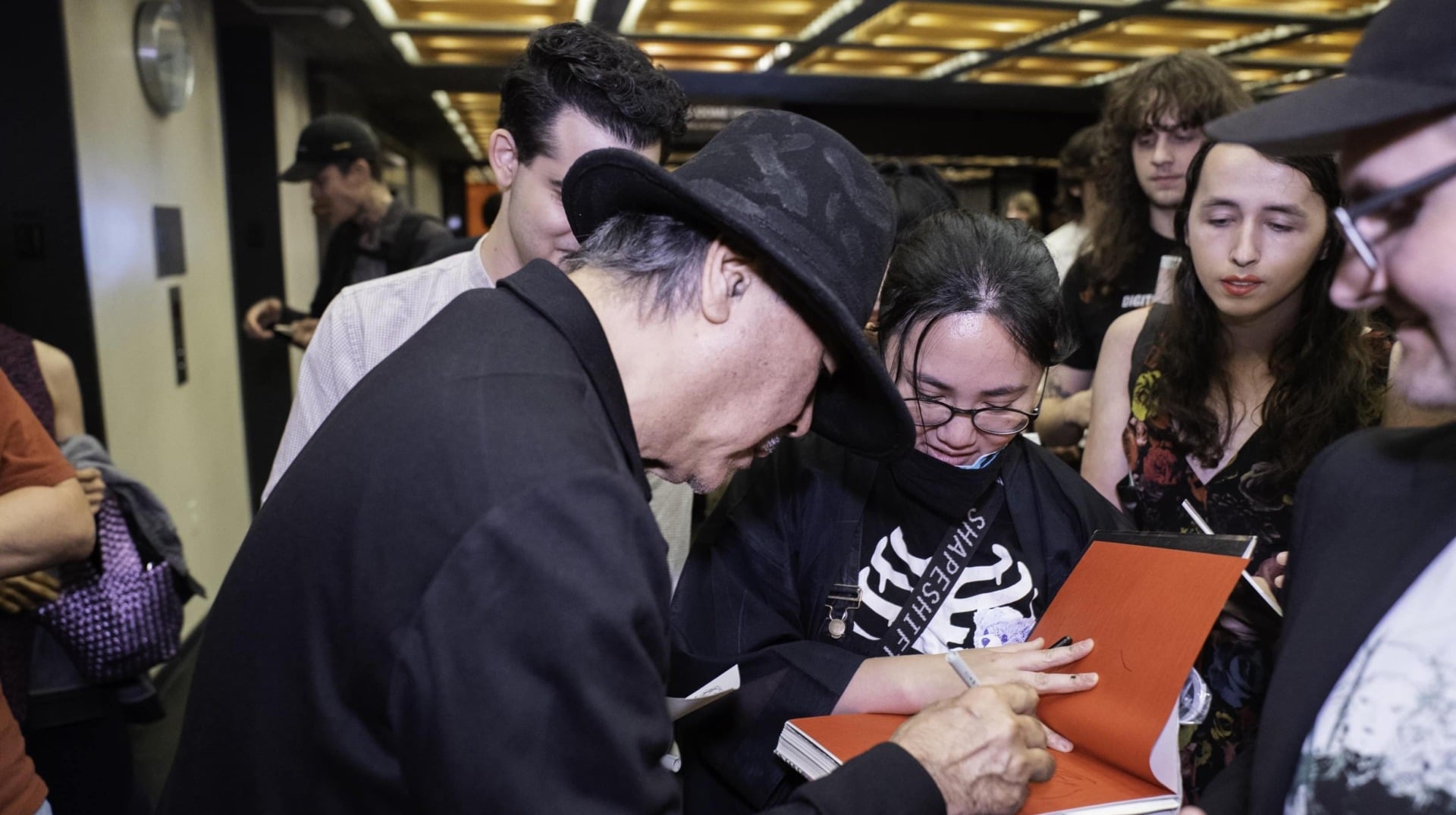 Amano se centra en un autógrafo.
